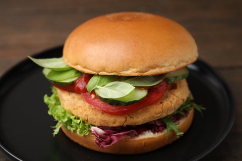 Delicious vegan burger with chickpea cutlet on wooden table