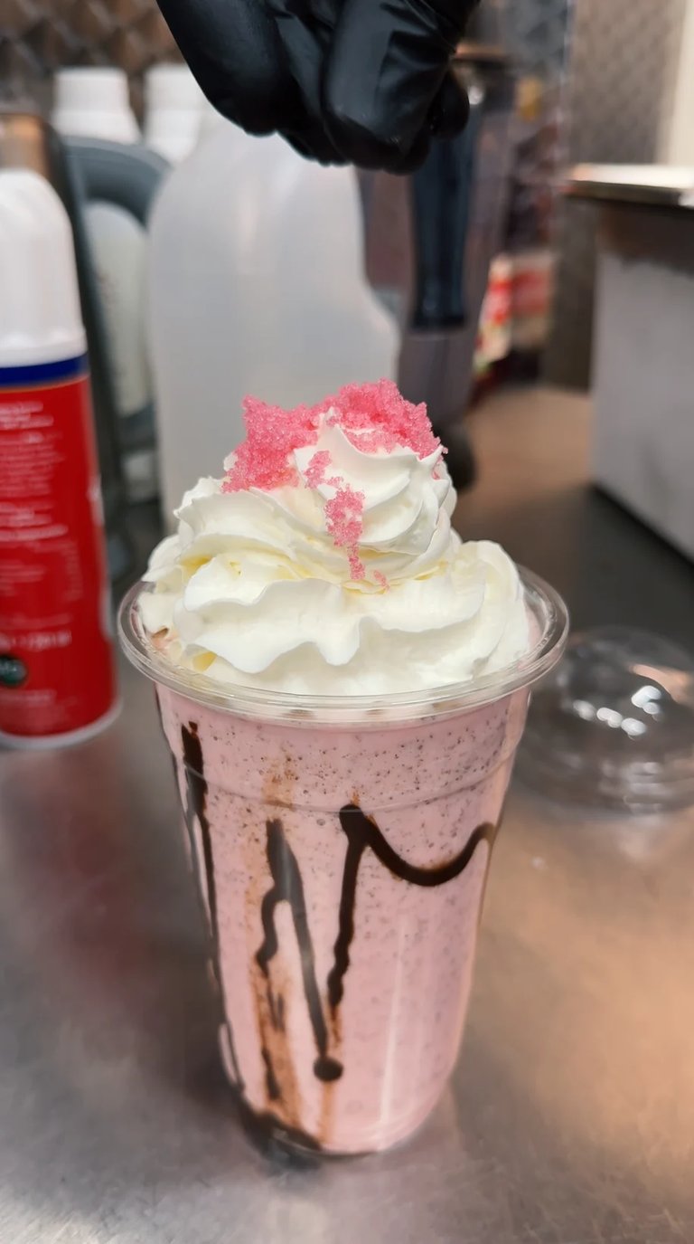 Pink milkshake with whipped cream and sprinkles