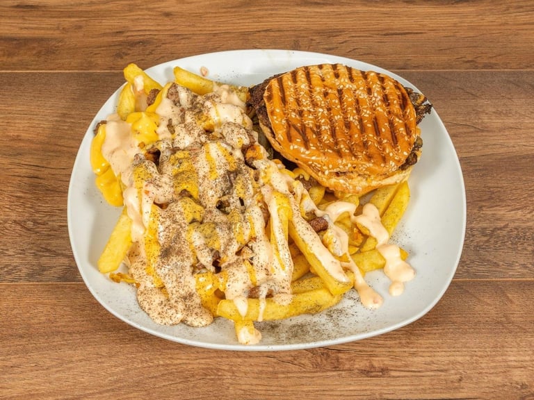 Grilled sandwich with waffle pattern and pile of crispy fries dusted with seasoning on white plate