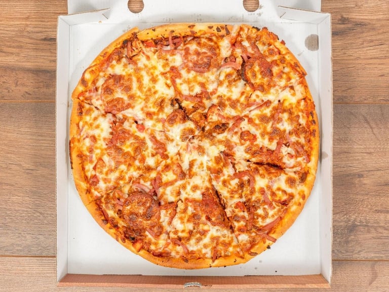 Pepperoni pizza in white delivery box on wooden surface, showing melted cheese and toppings